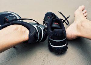 runner with shoes off stretching feet to prevent injury